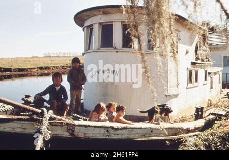 Les enfants des pêcheurs jouent sur un bateau rarement utilisé; Bayou Gauche ca.Février 1973 Banque D'Images