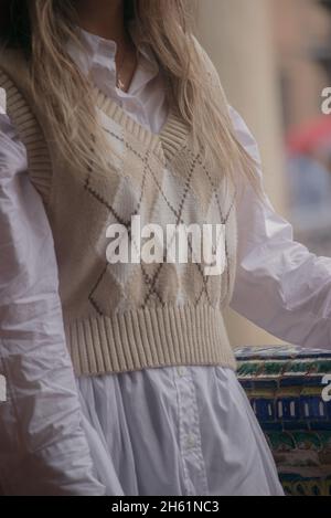 Gros plan fille non reconnaissable portant un gilet tricoté, tenue automne-hiver 2021 tendance lors d'une journée de pluie en plein air. Banque D'Images