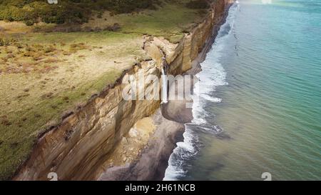 Cascade sur la falaise de Golovinsky sur l'île de Kunashir, îles Kuril, Russie.Photographie aérienne. Banque D'Images