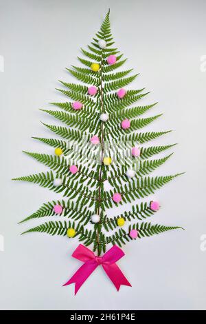 Arbre de Noël en feuilles de fougères naturelles ruban décoratif noeuds sur fond blanc, plat Banque D'Images