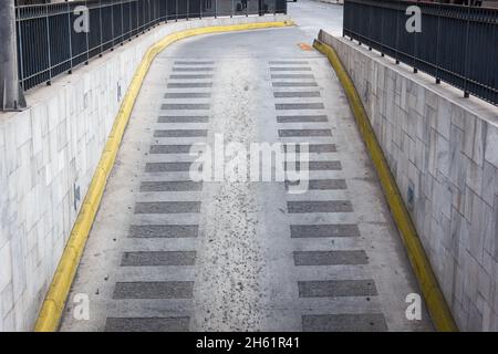 Chaussée grise de la rampe de garage avec lignes jaunes sur le côté.Sortie d'entrée de stationnement Banque D'Images