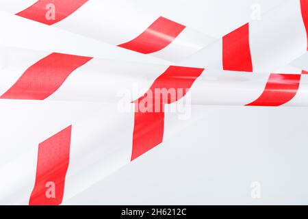 Un ruban avec des bandes rouges et blanches pour la barrière empêche le passage.Ruban adhésif sur fond blanc Banque D'Images