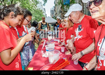 New York, Rubin Museum of Art, Block Party, arts et artisanat faisant des fleurs en papier, asiatique hommes filles adolescents adolescents bénévoles seniors citoyens Banque D'Images