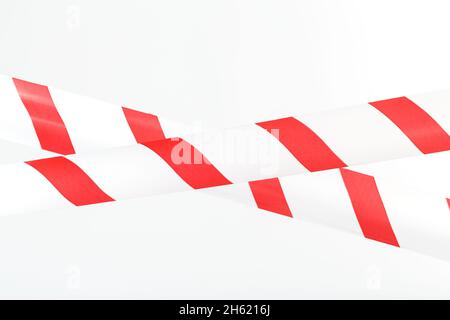 Un ruban avec des bandes rouges et blanches pour la barrière empêche le passage.Ruban adhésif sur fond blanc Banque D'Images