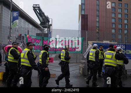 Glasgow, Écosse, Royaume-Uni.Les policiers se tiennent à côté d’une bannière qui se lit comme suit : « combien de CP peuvent arrêter le chaos climatique ? »,Qui avait été attaché à la clôture par des manifestants pour le climat, à la clôture de sécurité à l'extérieur du lieu de la Conférence des Nations Unies sur les changements climatiques COP26, alors que la conférence et les réunions s'apprêtaient à une finale à l'intérieur, à Glasgow, en Écosse, le 12 novembre 2021.Photo: Jeremy Sutton-Hibbert/ Alamy Live News. Banque D'Images