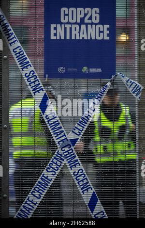 Glasgow, Écosse, Royaume-Uni.Les policiers se tiennent à côté d’une bande magnétique qui lit « Climate crime Scene » (la scène de la criminalité climatique), qui avait été attachée sur la clôture par des manifestants, à la clôture de sécurité devant le lieu de la COP26 de la Conférence des Nations Unies sur les changements climatiques, alors que la conférence et les réunions s’apprêtaient à une finale à l’intérieur, à Glasgow, en Écosse, le 12 novembre 2021.Photo: Jeremy Sutton-Hibbert/ Alamy Live News. Banque D'Images