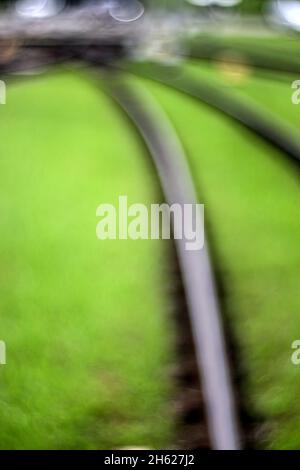 rails du rail léger dans le lit de voie vert, flou abstrait Banque D'Images