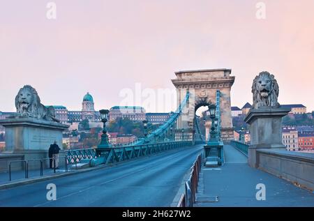 L'entrée au pont de la chaîne est écorée avec des lions de pierre étonnants et les lampes vintage, l'immense arche de pierre du pont est vue en arrière-plan Banque D'Images