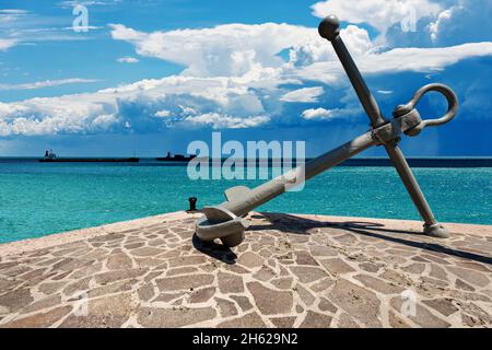 Grande ancre sur le rivage de la mer avec beau paysage marin sur fond avec des navires et des nuages cumulonimbus dans le ciel bleu.Mer Méditerranée. Banque D'Images