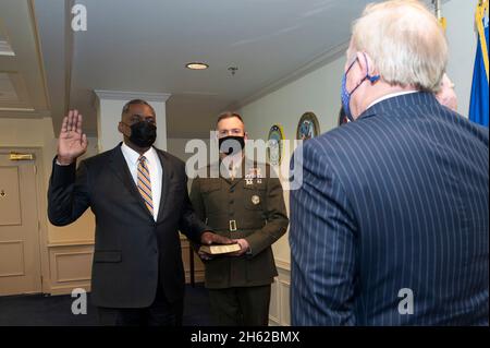 Reportage : David Muir, directeur des services du quartier général de Washington, a juré dans Lloyd J. Austin III comme secrétaire à la défense, Pentagone, Washington, D.C., le 22 janvier,2021. Tenir la Bible est l'adjoint militaire junior au secrétaire de la Défense, corps de Marine, lieutenant. Colonel Caleb Hyatt. Banque D'Images