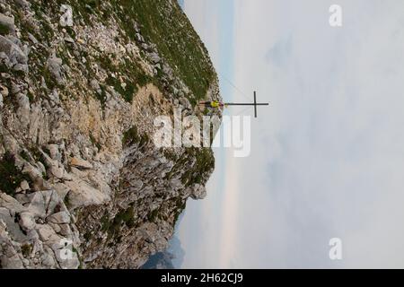 jeune femme sur la randonnée depuis le sommet de la brunnsteinspitze (2197 mètres), dans la vallée, de l'avant, sommet croix en arrière-plan, autriche, tyrol, scharnitz, karwendel parc naturel, Banque D'Images