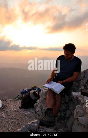 le jeune homme aime le coucher de soleil en face de la croix de la viererspitze 2054 m, livre de sommet, entrée, karwendel, allemagne, bavière, haute-bavière, werdenfelser pays, isar vallée, mittenwald Banque D'Images