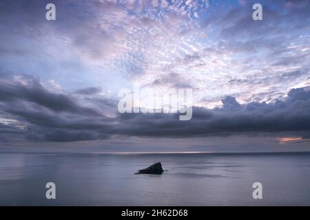 coucher de soleil sur la mer obscurci par les nuages de pluie Banque D'Images