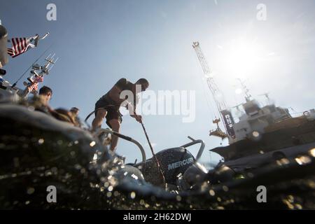 Une ligne d'alimentation en air de surface est acheminée vers un plongeur CBP BORSTAR américain alors que le plongeur inspecte la coque d'un navire de cargaison avant le déchargement dans le port maritime de Panama City, en Floride, le 27 mai 2016. Banque D'Images