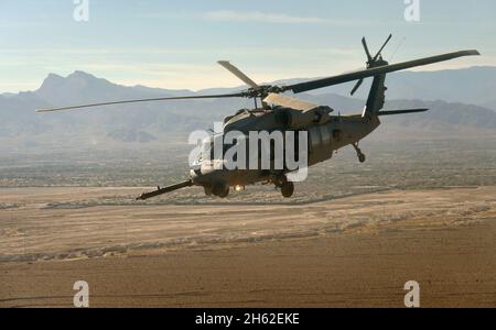 Un hélicoptère Black Hawk transportant des membres de la délégation du sous-secrétaire de la Défense Bob Work survole le terrain du désert après avoir quitté la base aérienne de Creech le 4 novembre 2014. Banque D'Images