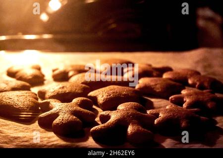 Préparation noël biscuits maison de pain d'épice sur une plaque de cuisson dans le four Banque D'Images