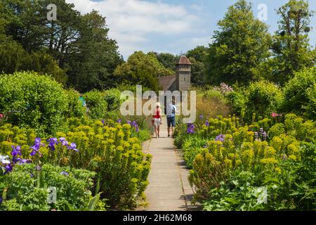 angleterre, hampshire, hinton ammpner maison, couple marchant dans le jardin de la cuisine fortifiée Banque D'Images
