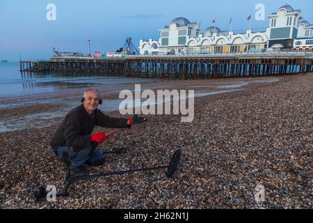 angleterre,hampshire,portsmouth,southsea,homme détection de métal sur la plage et quai de southsea Banque D'Images