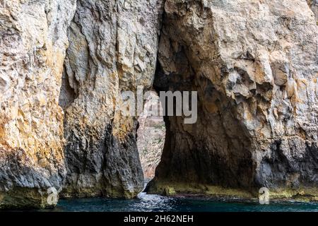 Bords rocailleux de la crique de iż-Żurrieq, près de la Grotte bleue, Malte, sortant de la mer Méditerranée et éclairé par le soleil du matin.Formations rocheuses avec Banque D'Images