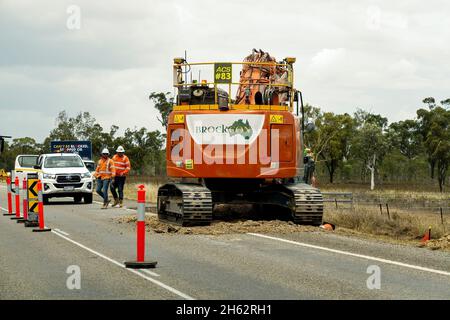 Bruce Highway Mackay à Townsville, Queensland, Australie - novembre 2021 : ouvriers de la construction à côté d'une énorme machine effectuant des travaux de terrassement sur la construction de l'autoroute Banque D'Images