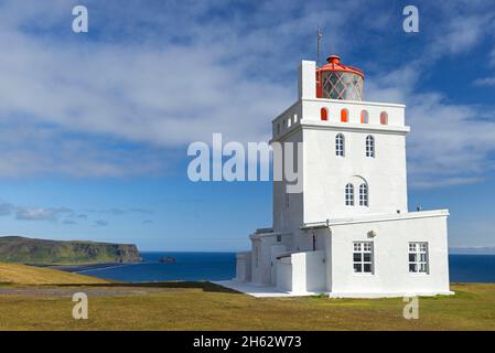 phare à cape dyrholaey sur la côte sud de l'islande, en arrière-plan la crête reynisfjall et le roc pinnacles reynisdrangar, islande Banque D'Images