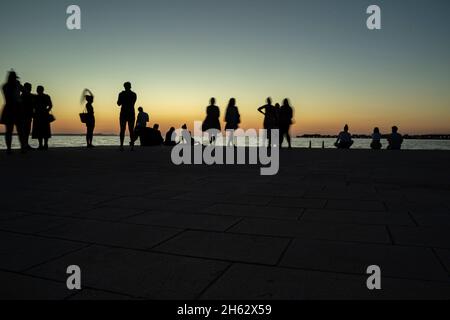 silouette de personnes regardant le spectaculaire coucher de soleil à zadar, croatie Banque D'Images