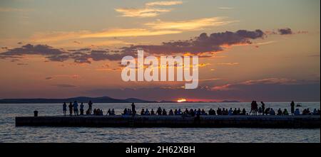 personnes debout sur une jetée au coucher du soleil à zadar,dalmatie,croatie Banque D'Images