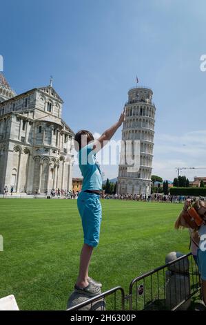 une image touristique typique de la tour penchée de pise, toscany, italie, où le touriste ressemble à s'il soutient la tour. Banque D'Images