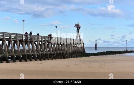 Touristes visitant la jetée de Courseulles-sur-Mer, Calvados, Normandie, France. Banque D'Images