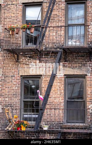 Le rose plein d'humour Flamingo décore une évasion au feu à l'extérieur d'un appartement dans la ville de New York, États-Unis Banque D'Images