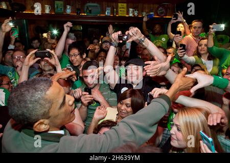 Le président Barack Obama accueille la foule au Dubliner, un pub irlandais à Washington, D.C., le jour de la Saint-Patrick, le samedi 17 mars 2012 Banque D'Images