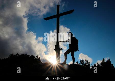 homme à la croix de sommet, randonnée à l'écart 1829m,estergebirge,coucher de soleil,arrière-feu,tenant croix,europe,allemagne,bavière,haute-bavière,werdenfelser land,alpenwelt karwendel,isar vallée,krün Banque D'Images