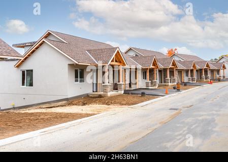 Rangée de maisons semi-individuelles en cours de construction dans un développement de logements un jour d'automne clair Banque D'Images