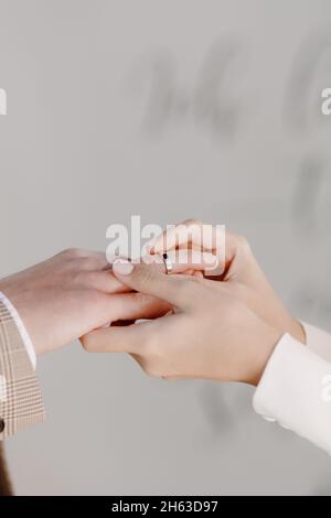 Mains de la jeune mariée de près, où la mariée met l'anneau sur le marié Banque D'Images
