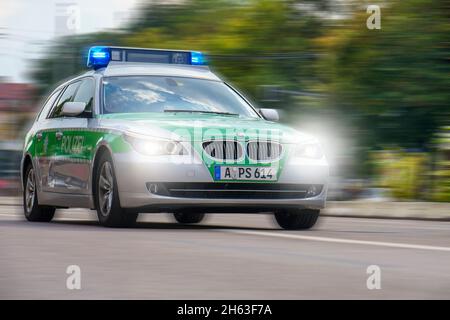 une voiture de police traverse la ville d'augsbourg à grande vitesse et aux feux bleus Banque D'Images