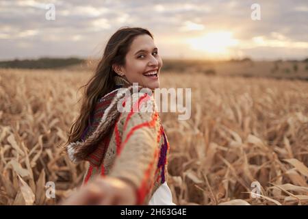 Suivez-moi concept.Homme suivant petite amie tenant les mains dans la ferme.POV.Bonne jeune femme à la tête de son petit ami.Apprendre à connaître la ferme.Tourisme. Banque D'Images