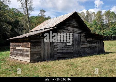 Ancien bâtiment rustique antique en bois patiné avec un toit en métal dans un champ en Géorgie rurale, Etats-Unis. Banque D'Images