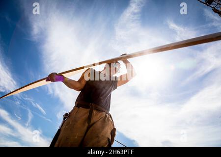 allemagne,bavière,construction d'une maison préfabriquée en bois, charpentier porte le panneau sur le toit, Banque D'Images