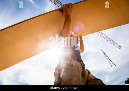 allemagne,bavière,construction d'une maison préfabriquée en bois, charpentier porte le panneau sur le toit, Banque D'Images