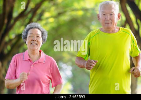 Bon couple asiatique senior jogging dans le parc Banque D'Images