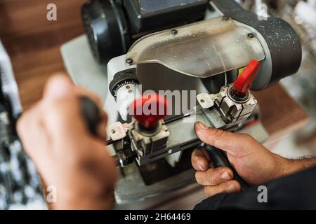 Fermer la vue de la machine à copier les clés avec la clé.Dupliquer la machine Créer une nouvelle clé.Thème serrurier.Touches vierges pour la coupe.Ouvre-porte de voiture moderne noir. Banque D'Images