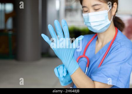 Personnel médical portant des gants pour se préparer à l'éclosion de maladies transmissibles virus Corona (COVID-19) Banque D'Images