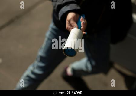 Ruban adhésif pour enlever la laine des vêtements.Outil pour nettoyer les vêtements des cheveux.Fille tient dans sa main un objet pour enlever la saleté des choses. Banque D'Images