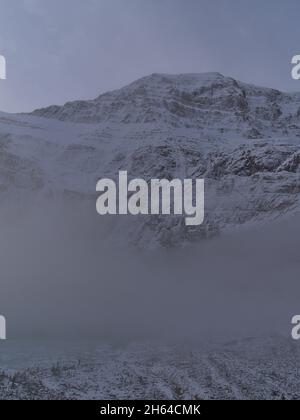 Vie du majestueux mont Edith Cavell avec une face rocheuse enneigée dans le parc national Jasper, Alberta, Canada, dans les montagnes Rocheuses, au-dessus d'un épais brouillard matinal. Banque D'Images