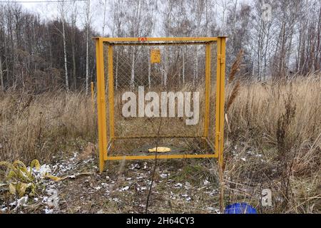 Pilier en béton jaune avec un panneau d'avertissement gaz, à l'extérieur dans l'herbe.Tuyaux de gaz, vannes et dispositifs pour un gaz Banque D'Images