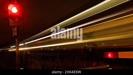 Un train rapide de soirée avec des lignes de lumière dans l'obscurité Banque D'Images