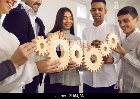 Les gens qui se joignent à Gears comme métaphore pour un travail bien coordonné et pour construire un système d'affaires efficace Banque D'Images