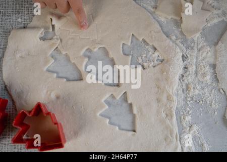 Forme pour les biscuits de Noël et la pâte fraîche sur la table.Coupe de pain d'épice avec un moule et un arbre de Noël. Vue du dessus. Banque D'Images