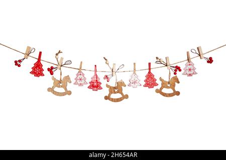 Guirlande de Noël faite de jouets en bois et de baies rouges isolées sur fond blanc Banque D'Images