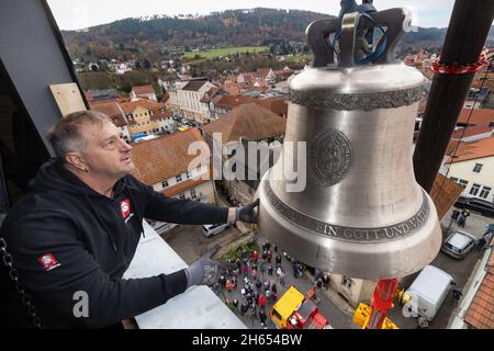 Bad Blankenburg, Allemagne.13 novembre 2021.Uwe Nothnagel utilise une grue pour soulever la première des deux nouvelles cloches dans la tour de l'église Saint-Nikolai.Les deux nouvelles cloches ont été décorées avec soin et consacrées à l'avance et conduits à travers la ville.Ils remplacent deux cloches en acier de presque 100 ans qui ne pouvaient plus être suspendues.Credit: Michael Reichel/dpa/Alay Live News Banque D'Images